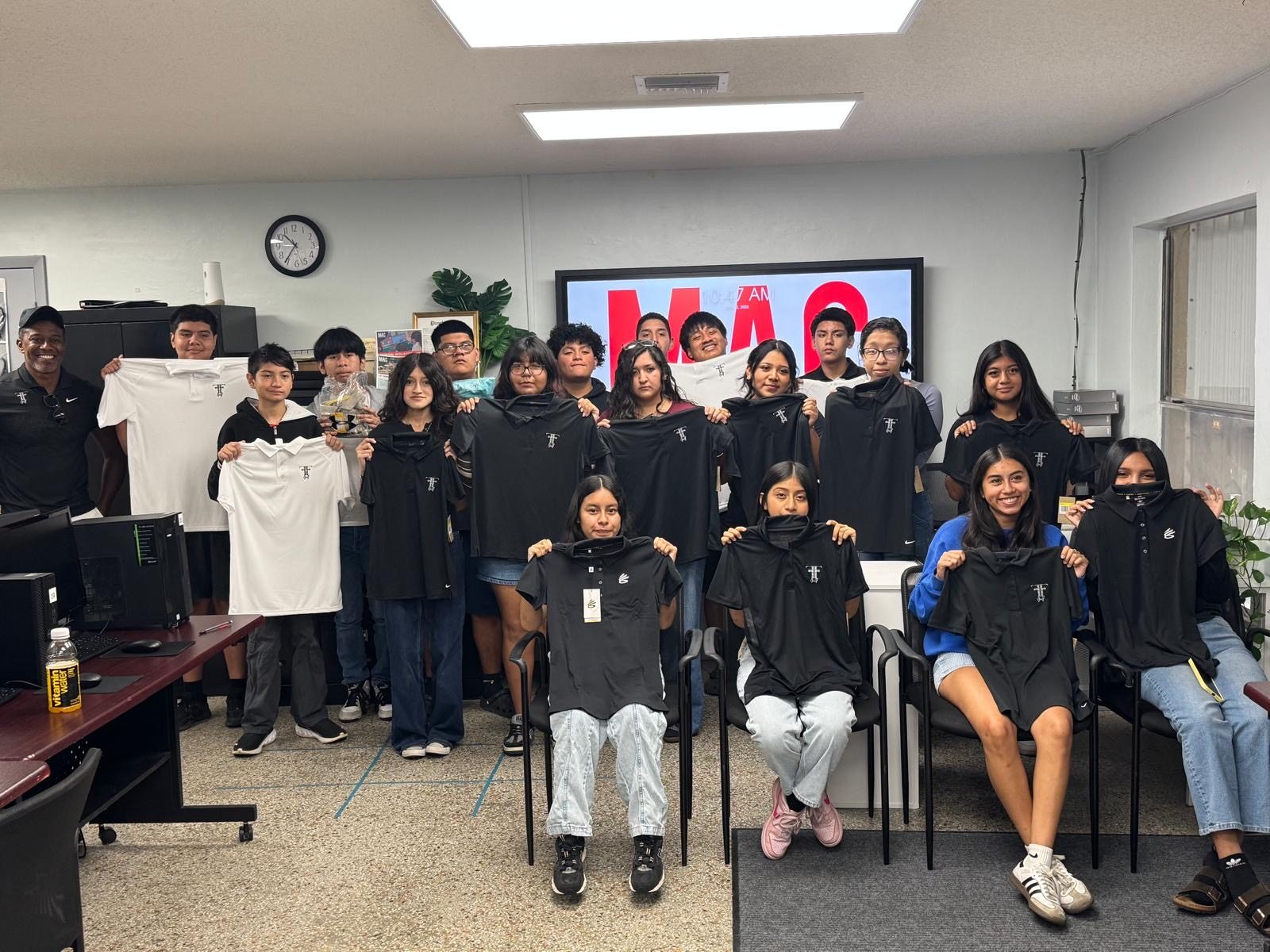 Group of FFGF community clinic youth holding new FFGF polo shirts