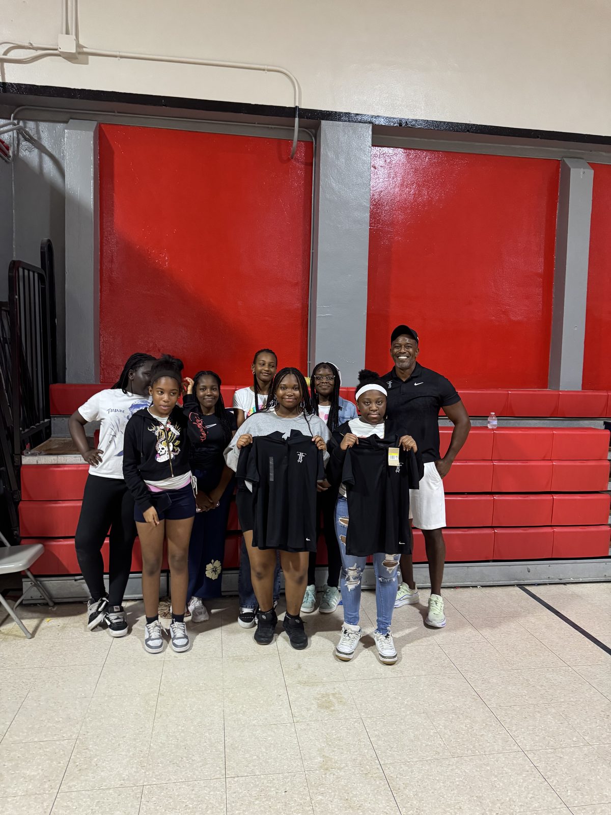 Group of FFGF girls program participants indoors holding FFGF apparel