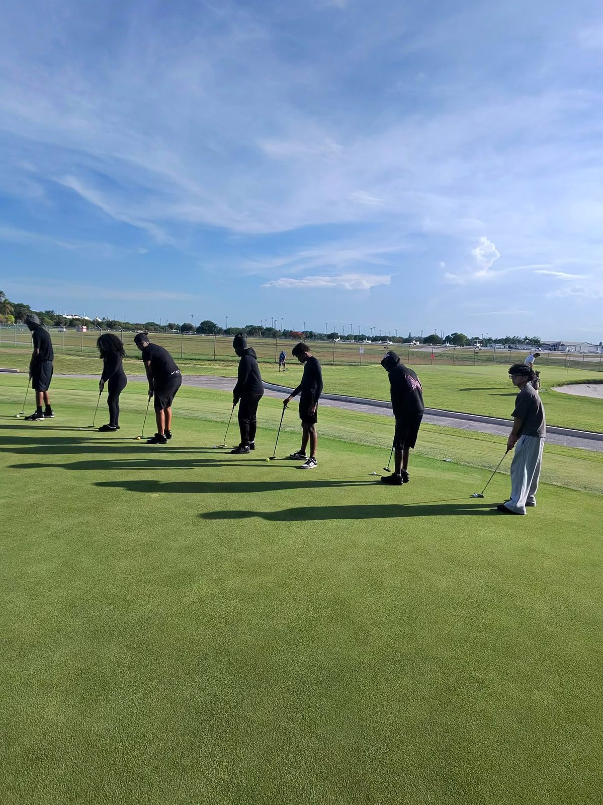 FFGF youth participants lined up on the putting green during golf instruction at sunrise, South Florida