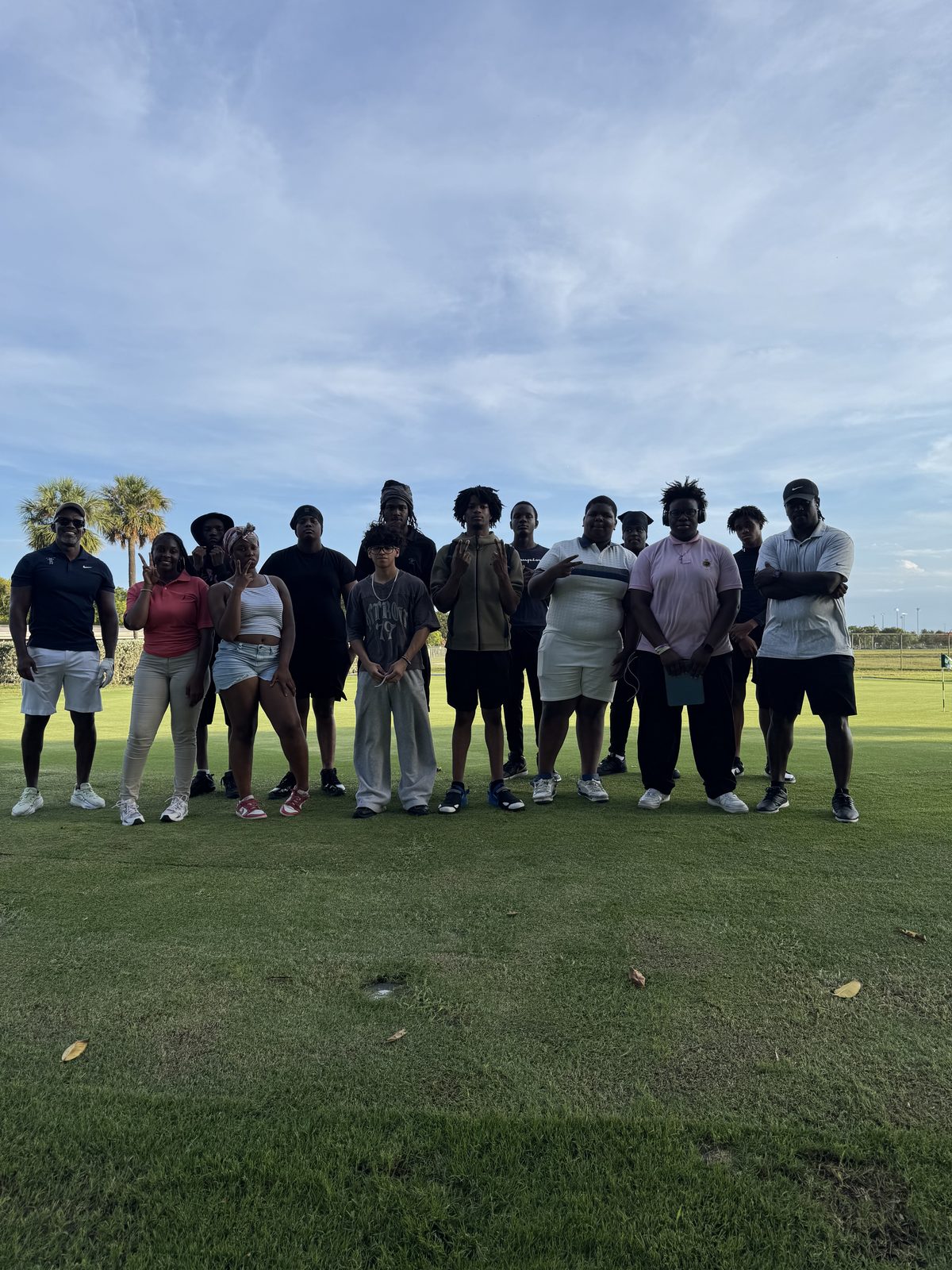 Large group of FFGF summer program youth and coaches gathered on the range at dusk