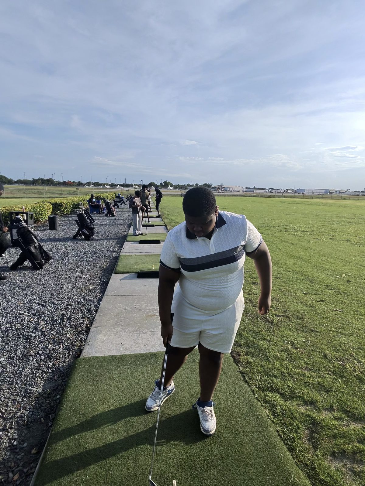 FFGF youth participant focused on his stance and setup at the driving range
