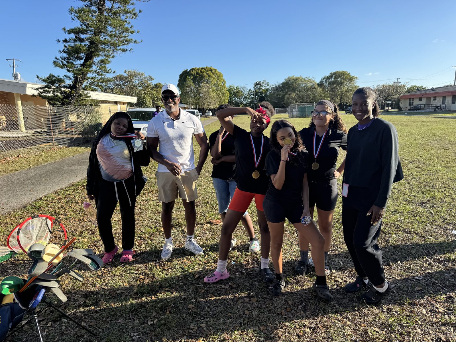 FFGF youth golf program participants posing outdoors with medals and clubs after a clinic